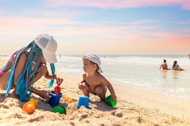 Sœur aînée jouant avec son jeune frère échoué près du rivage pendant les vacances d'été