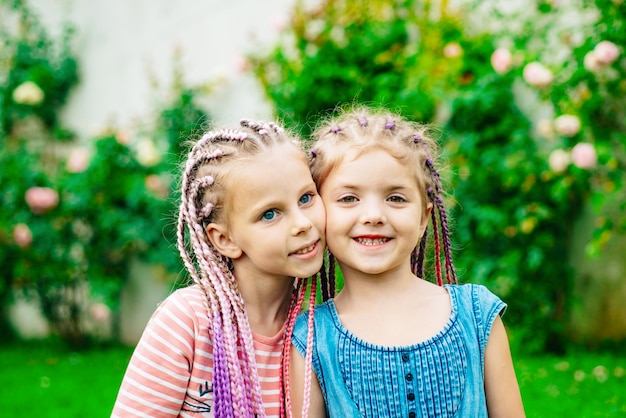 Sœur dreadlocks s'amusant jardin de printemps en plein air. Joli portrait positif de la meilleure amie de jolies jeunes filles au printemps.