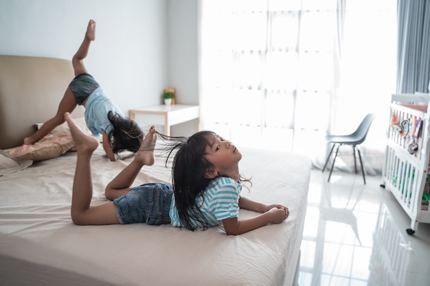 Sœur enfant s'amusant à sauter sur le lit