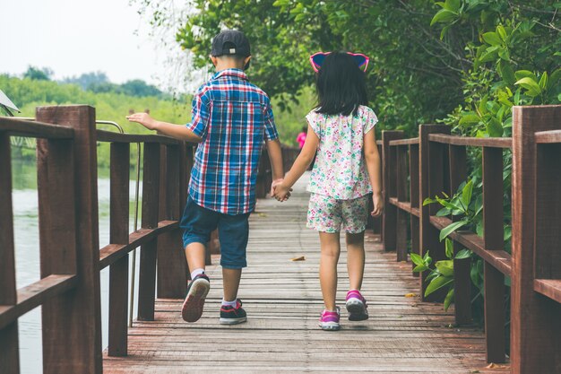 Sœur et frère marchent ensemble dans le pont en bois