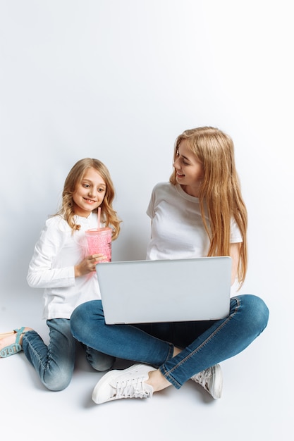 Une soeur ou une jeune maman avec sa fille regardant un film sur mon ordinateur portable, amusant, riant