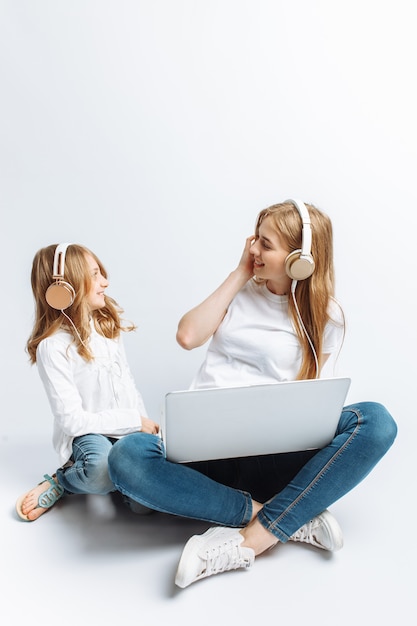 Une soeur ou une jeune maman avec sa fille regardant un film sur mon ordinateur portable, amusant, riant