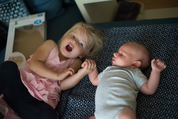 Sœur avec un mignon bébé au lit à la maison