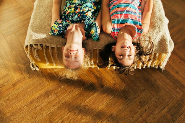 Photo sœur s'amuse dans le mal et partage des moments d'amour. petites filles s'amusant ensemble au lit. petites filles jouant à la maison sur le lit.