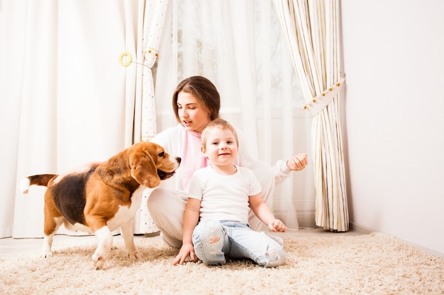 Une soeur et son petit frère jouent avec leur beagle