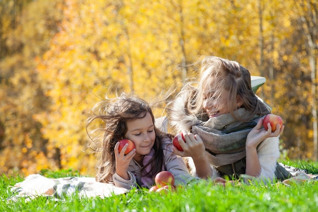 Sœurs gaies jouant avec sur pique-nique d'automne