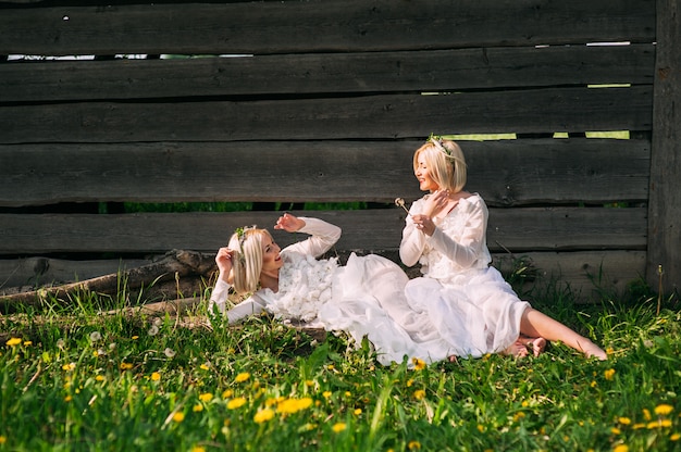 Soeurs jumelles assis à un mur en bois