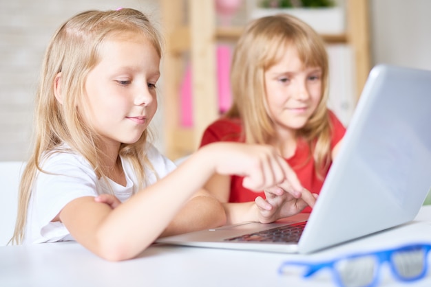 Sœurs mignonnes à l'aide d'un ordinateur portable