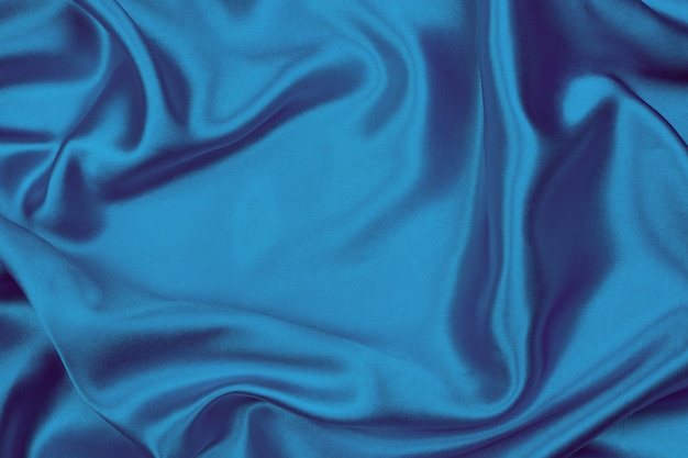 La soie bleue élégante lisse ou la texture satinée peuvent être utilisées comme fond abstrait, tissu