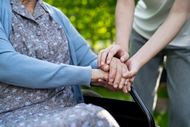 Soignant tenant la main d'une femme âgée asiatique aide patient et voiture à l'hôpital