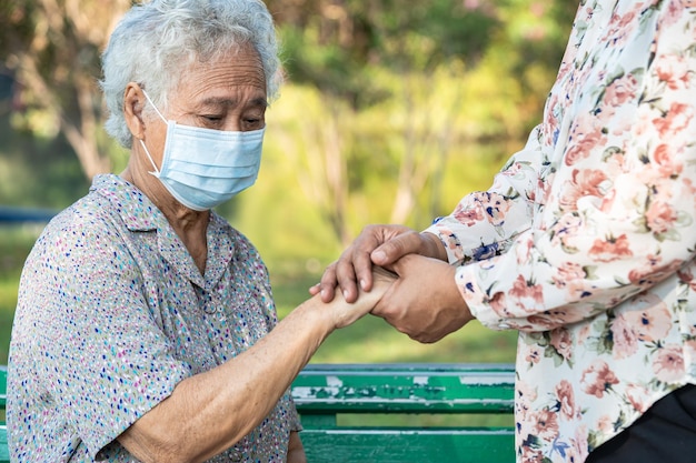 Soignant tenant par la main une femme âgée asiatique patiente avec des soins d'amour encourager et empathie