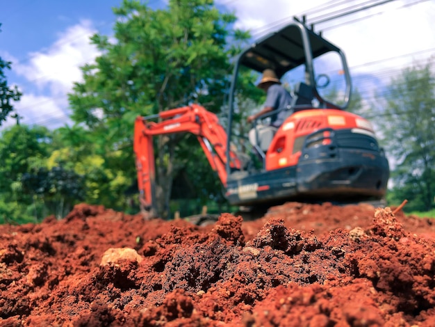 Soil à proximité de l'excavatrice floue pour rénover le site en préparation du versement de la dalle de béton Concept de construction