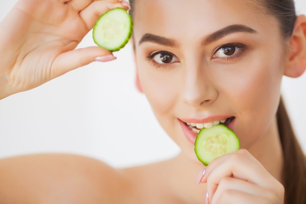 Soin de la peau. Belle jeune femme avec des concombres sur les yeux