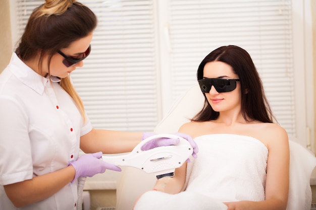 Soin de la peau. Femme adulte ayant une épilation au laser dans un salon de beauté professionnel