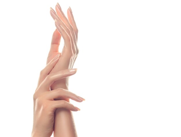 Soin de la peau des mains. Mains de belle femme avec manucure rose clair sur les ongles.