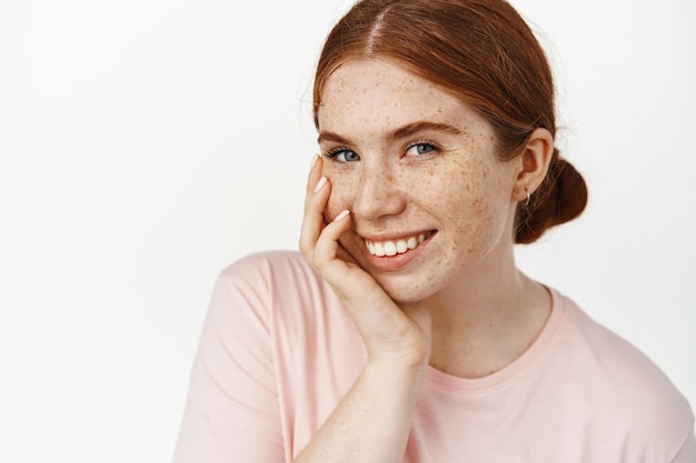 Soin De La Peau. Visage De Jeune Fille Rousse Adolescente Sans Maquillage, Visage Pâle Naturel Et Sourire Parfait Blanc, Expression Franche, Joue Tendrement Touchante, Effet De Routine De Soins Cosmétiques