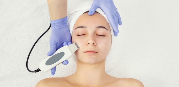 Soin visage rajeunissant. Modèle recevant un massage thérapeutique de levage dans un salon de beauté SPA. Exfoliation, stimulation et hydratation. Cosmétologie esthétique, vue de dessus, espace de copie, recadrage