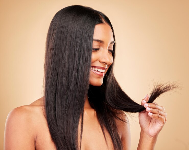 Photo soins capillaires bien-être et portrait de femme dans un studio avec pointes fourchues pour le traitement de kératine en salon cosmétique de beauté et photo de modèle féminin indien avec coiffure isolée par un fond marron