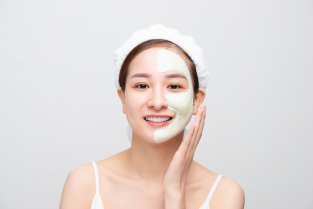 Soins du visage beauté. Portrait de jeune fille Asain touchant sa peau du visage douce et parfaite. Sur fond blanc.