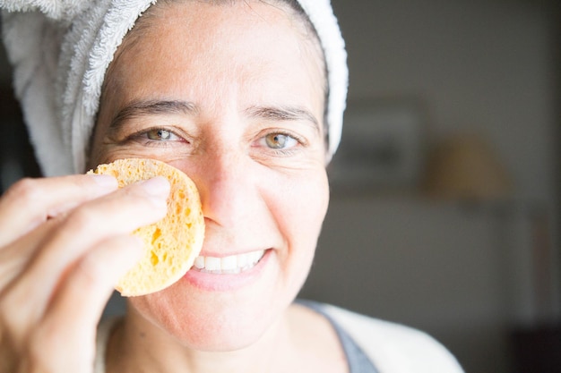 Soins du visage et du corps avec des crèmes. Heureuse femme d'âge moyen