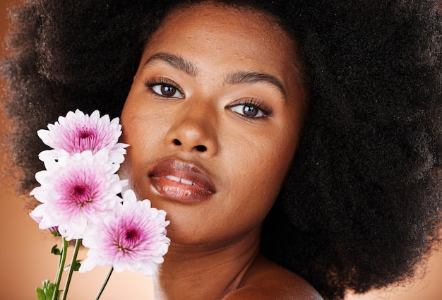 Soins de la peau aux fleurs et cheveux naturels de femme noire dans un portrait en studio pour les cosmétiques de beauté et la promotion de produits respectueux de l'environnement