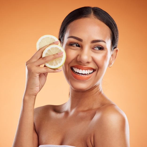 Soins de la peau du visage et femme au citron pour la santé, le bien-être et la vitalité sur fond de studio orange Sourire modèle et femme du Canada avec des agrumes pour des minéraux de vitamine c sains ou une nutrition