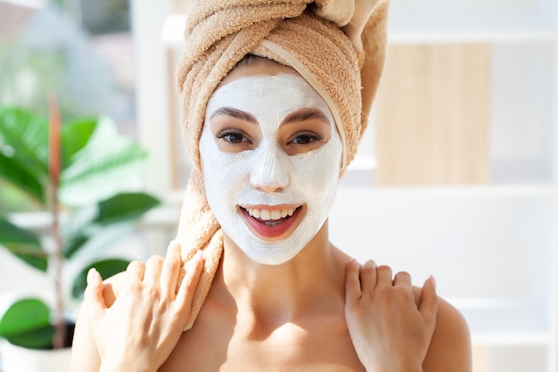 Soins de la peau, femme avec une belle peau du visage, appliquant un masque sur le visage.