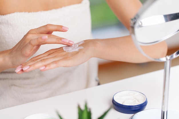 Soins de la peau, la femme porte une crème hydratante sur la peau.