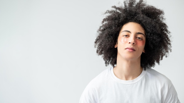 Soins de la peau de l'homme traitement du visage mode de vie métrosexuel confiant beau mec avec de longs cheveux bouclés bruns