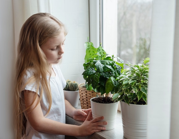 Soins des plantes d'intérieur, petite fille s'occupant des plantes d'intérieur