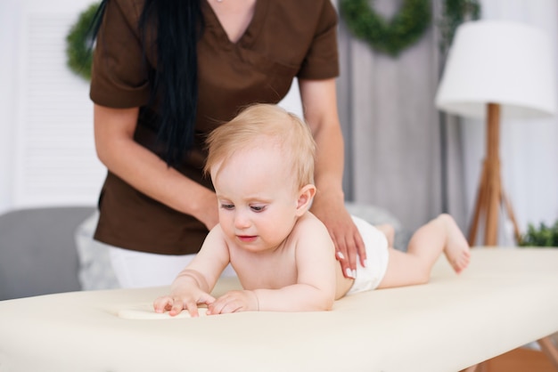 Soins de santé et concept médical. Bébé heureux ayant un massage avec une masseuse féminine professionnelle.