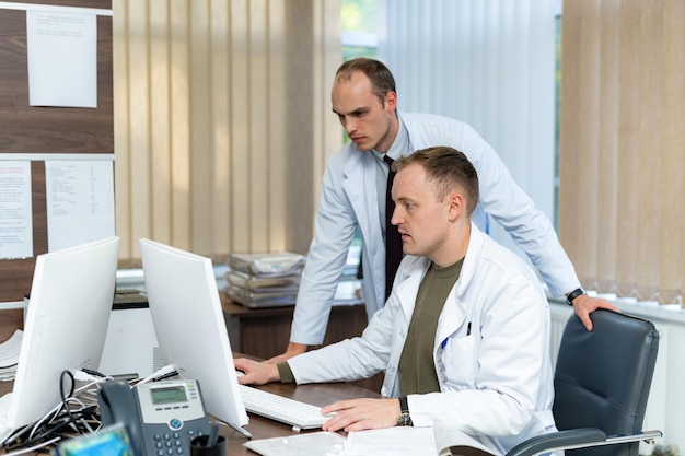 Soins de santé professionnels des patients dans un hôpital moderne Beau médecin spécialiste en uniforme travaillant sur ordinateur