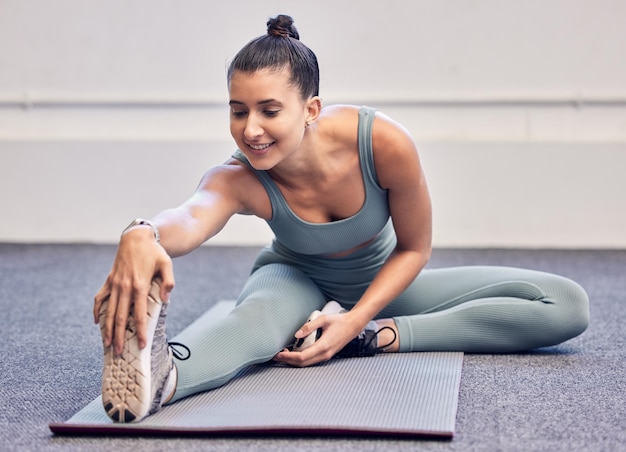 Soins de santé de remise en forme et femme qui s'étire les jambes dans la salle de sport se préparant à l'entraînement ou à l'entraînement