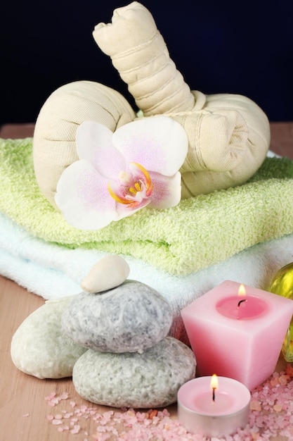 Soins de spa avec des fleurs d'orchidées sur une table en bois sur fond coloré