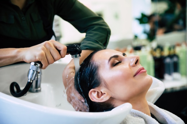 Soins de spa. Vue de dessus des mains du coiffeur lavant les cheveux de son client dans le salon avant le processus de coiffure.