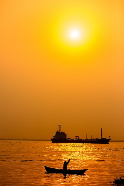 Soirée coucher de soleil doré un pêcheur pêchant au bord de la mer sur un bateau