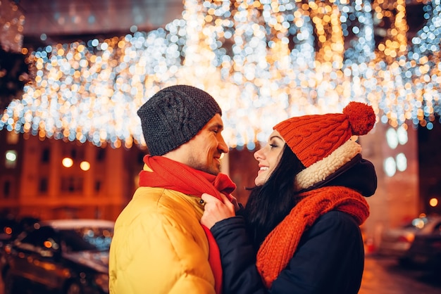 Soirée d'hiver, couple amoureux câlins dans la rue