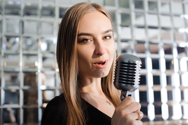 Soirée karaoké. Fille de beauté avec un chant de microphone. Soirée disco. Fête.