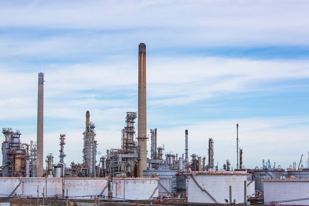 Soirée de scène de la tour de l'usine de raffinerie de pétrole du réservoir et de la colonne d'huile du réservoir de l'industrie pétrochimique ciel bleu et pelouse