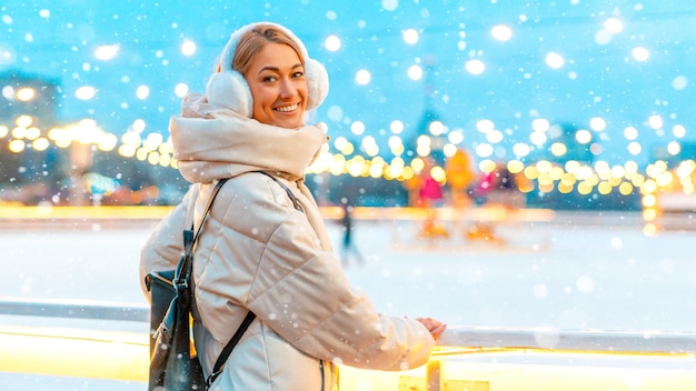 Soirée de vacances de Noël d'hiver femme debout à l'extérieur et sourire