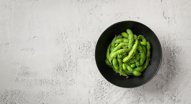 Soja edamame cuit à la vapeur sur un fond de béton gris vue de dessus espace de copie