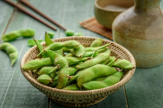 Soja japonais vert dans un bol en bois sur le bois de la table