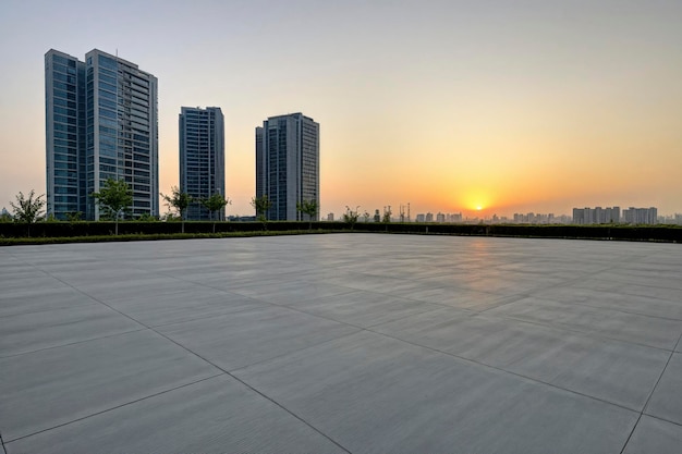 Le sol carré en béton et les bâtiments de la ville ont un fond de ciel au coucher du soleil