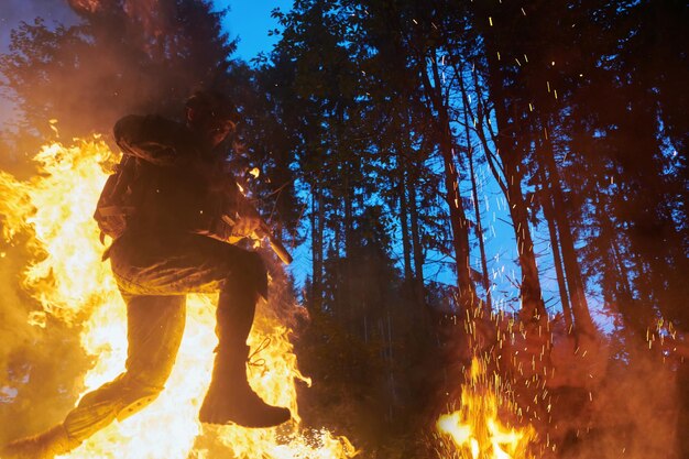 Soldat en action la nuit sautant sur le feu