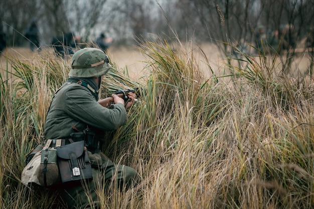 Le soldat allemand Wehrmacht se cache avec un fusil