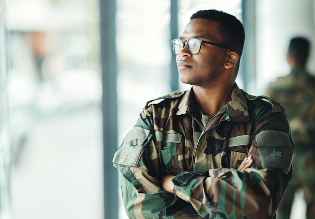 Soldat confiant pensant maquette et bras croisés dans la fierté du bâtiment de l'armée et service de héros professionnel Carrière militaire sécurité et courage homme noir en uniforme de camouflage à l'agence gouvernementale