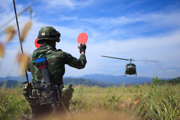 Soldat donnant le signal à l'hélicoptère d'atterrir