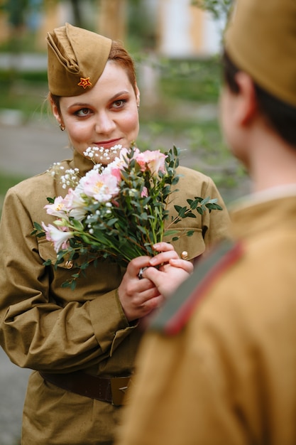 Un soldat donne un bouquet à une femme