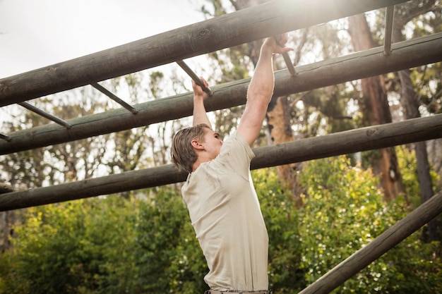 Soldat escalade des barres de singe