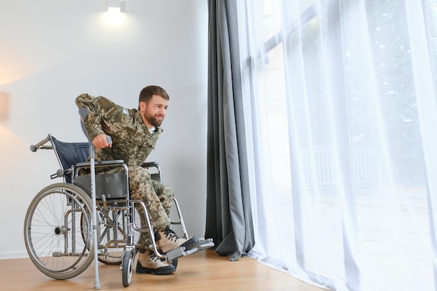 Un soldat essaie de se lever du fauteuil roulant.